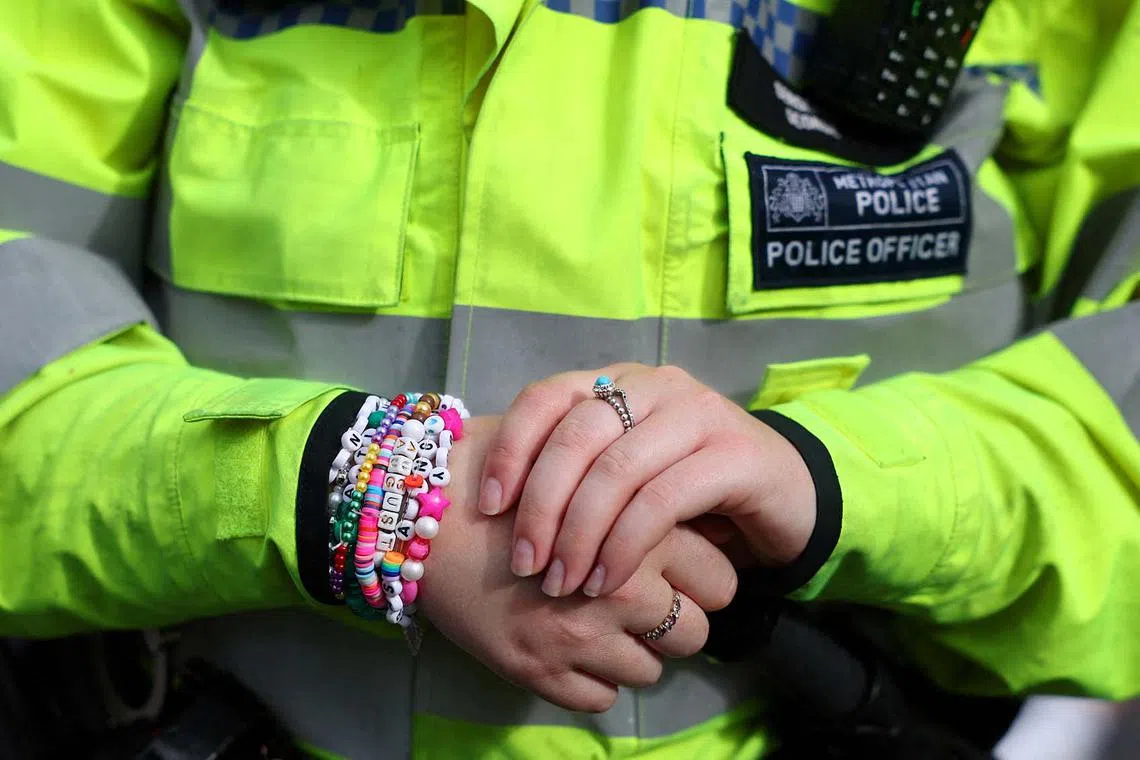 A police officer wears friendship bracelets, on the day of a Taylor Swift concert, following the cancellation of three Taylor Swift concerts in Vienna because of a planned attack, outside Wembley Stadium in London, Britain, August 15, 2024. REUTERS/Toby Melville TPX IMAGES OF THE DAY