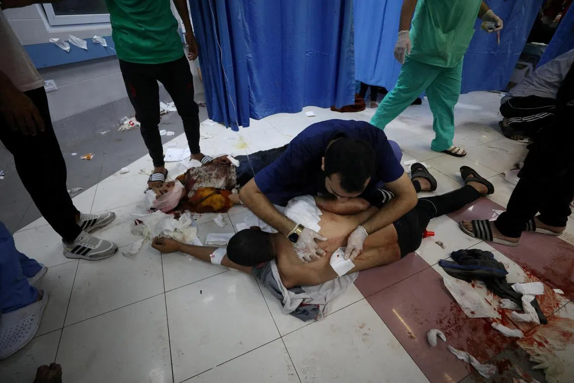 Injured people are assisted at Shifa hospital, after an air strike hit the nearby Al-Ahli al-Arabi hospital.