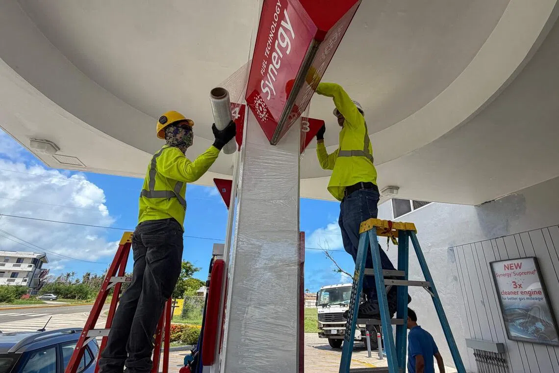 Workers secure a gas station ahead of the arrival of the forecasted Super Typhoon Bavi in Saipan, Northern Mariana Islands, on July 3.