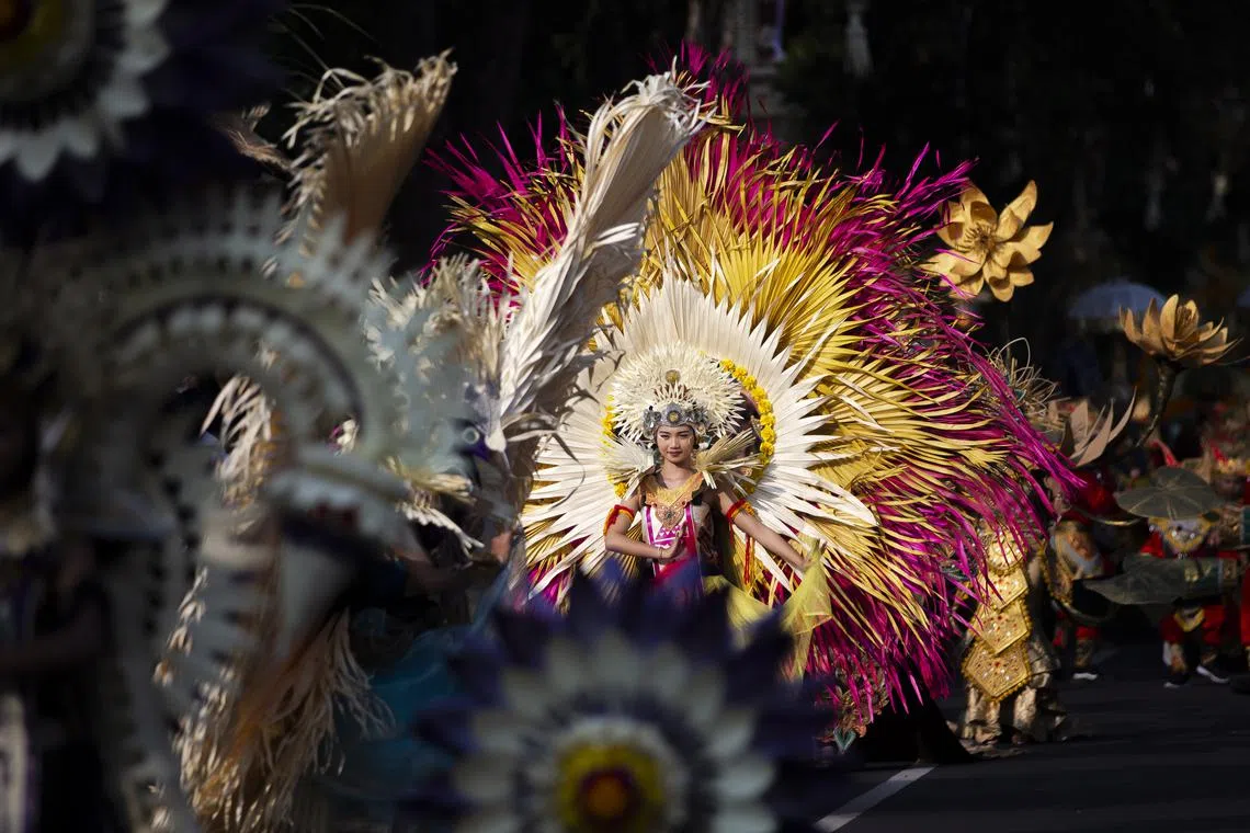 Dancers take part in a parade to mark the opening of the annual Bali Arts Festival on a main road in Denpasar city in Bali, Indonesia on June 18. This year's festival runs from June 18 to July 16, and features hundreds of performers.  