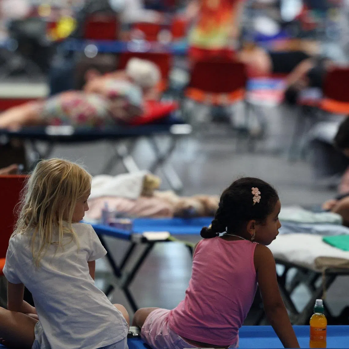 Children rest at the Bordeaux-Lac Exhibition Centre, which has been turned into a shelter for people displaced by a wildfire burning nearby amid worsening drought conditions following a heatwave and water shortages across much of France, in Bordeaux, Gironde, France, July 26, 2026. REUTERS/Florion Goga