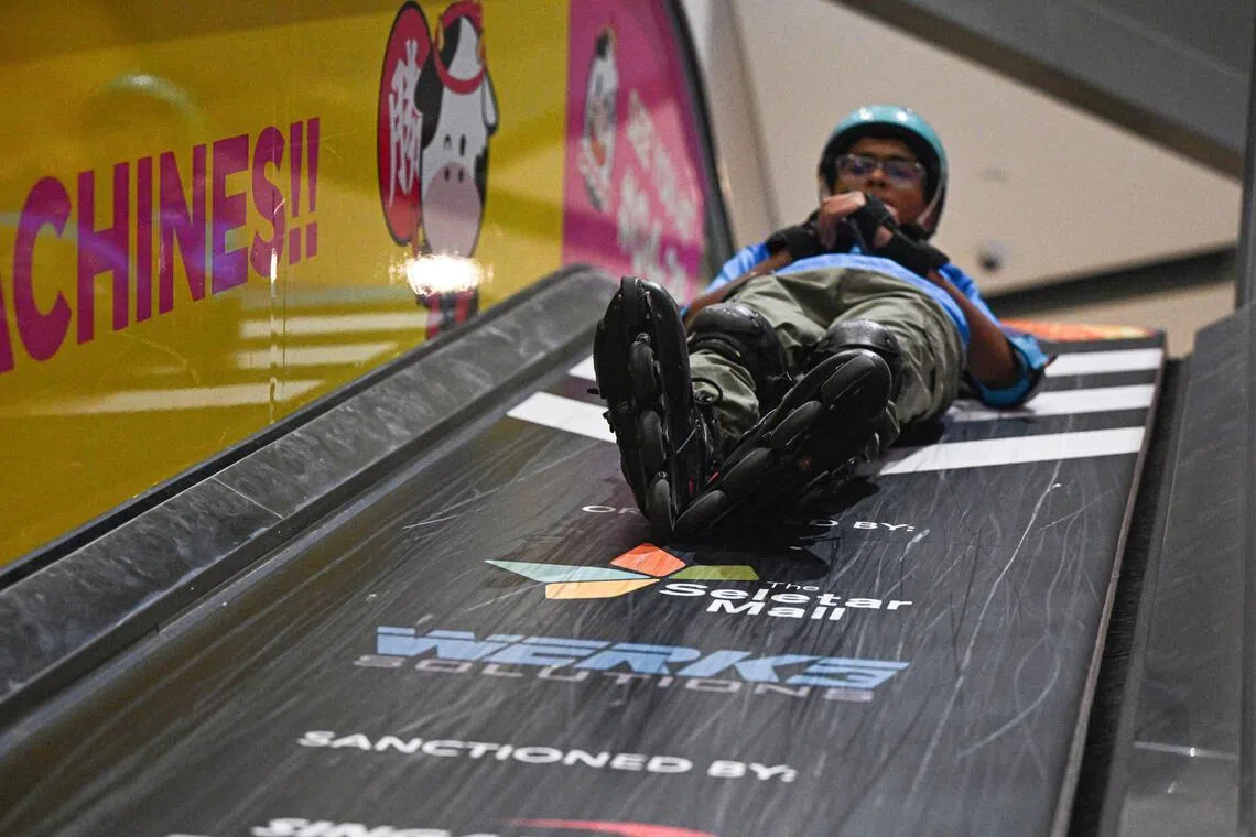 A participant sliding down the escalator slide.