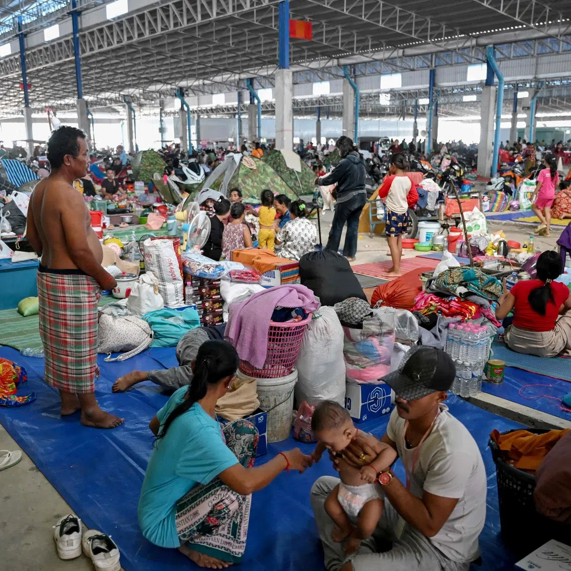 People resting at a temporary camp for displaced people set up at a former market in Banteay Meanchey province on Dec 13.
