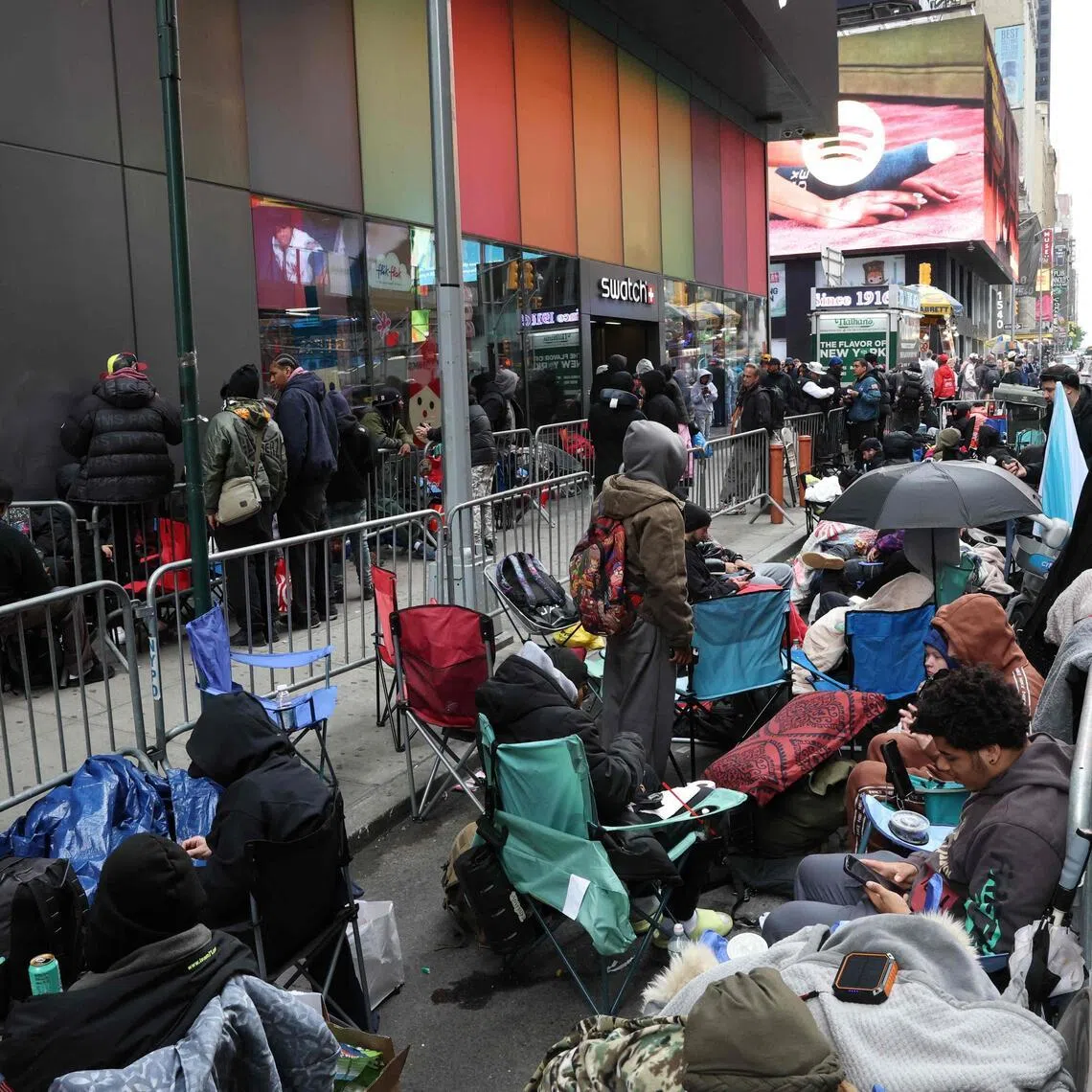 People camp out outside of a Swatch store at Times Square in New York.