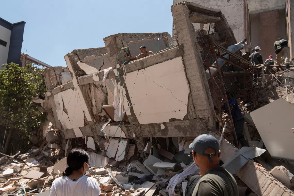 Residents dig through the debris of a damaged building after an earthquake in Cali, Colombia, on Aug 10.