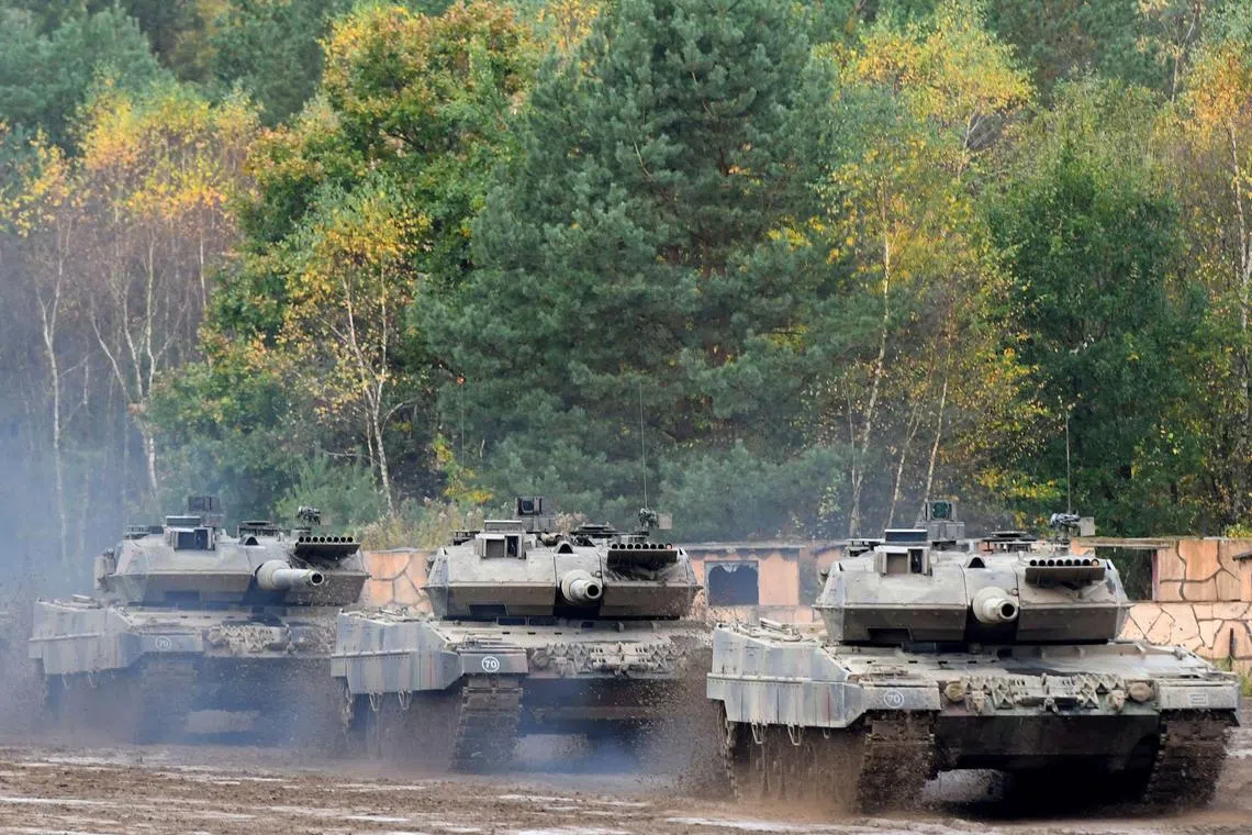(FILES) This file photo taken on October 13, 2017 shows an armored unit with Leopard 2 A7 main battle tanks of the German armed forces Bundeswehr driving through the mud in the context of an informative educational practice "Land Operation Exercise 2017" at the military training area in Munster, northern Germany. - NATO countries are set to announce new "heavier weapons" for Ukraine, the alliance's chief said on January 18, 2023, as Ukrainian President Volodymyr Zelensky called on his backers to speed up their decision-making. US Secretary of Defence Lloyd Austin will convene a meeting of around 50 countries on January 20, 2023 at the US-run Ramstein military base in Germany, including all 30 members of the NATO alliance. The German-made Leopard 2 is seen as one of the best-performing models worldwide and is widely used across Europe, meaning spare parts and ammunition could be easily sourced. (Photo by PATRIK STOLLARZ / AFP)