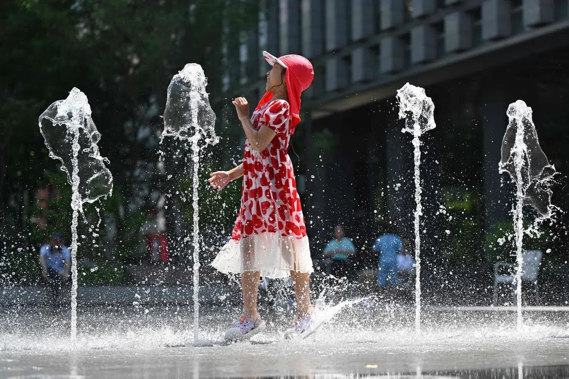 A child plays in a fountain to cool off in the central Gwanghwamun area of Seoul on July 10, 2025.
