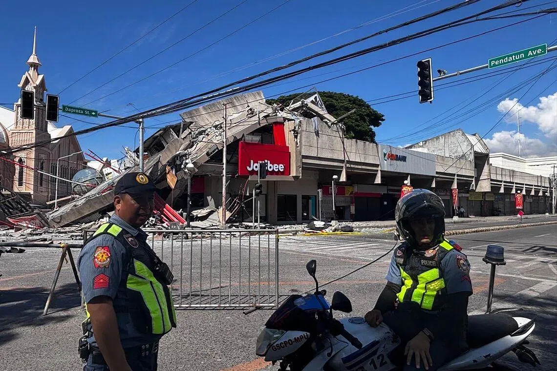 Police gather in front of a collapsed Jollibee fast food restaurant after an 7.8 magnitude earthquake in General Santos City on June 8.