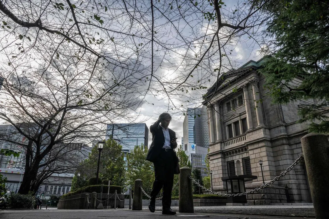 (FILES) This picture taken on October 30, 2024 shows a man walking past the Bank of Japan (BoJ) headquarters in Tokyo. The yen weakened against the dollar on December 19, 2024 after the Bank of Japan kept borrowing costs unchanged, extending a retreat for the currency that came after the US Federal Reserve forecast fewer rate cuts. (Photo by Yuichi YAMAZAKI / AFP)