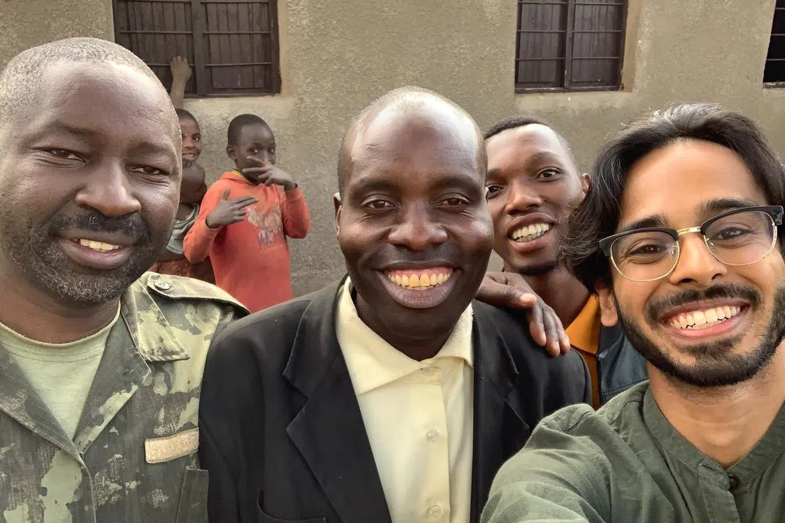 Singaporean Rohan Shah (right) with Rwandan gorilla tracking guide and community leader Patience (furthest left) and healer and pastor Bizimana David.