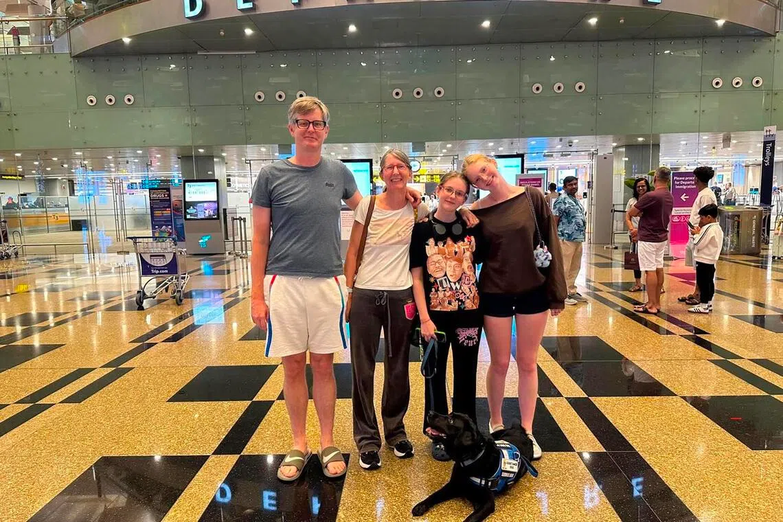 sfdog - Kiara Winnepenninckx, 18 (second from right), finds comfort in having Milo (lying on the ground), an autism assistance dog, with her.

Credit - Courtesy of Kiara Winnepenninckx