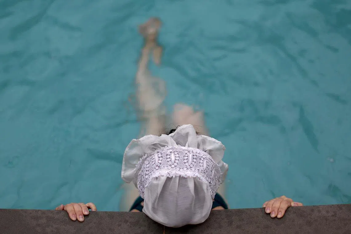 A woman in Victorian costume visits Cleveland Pools during the first day of reopening to the public in Bath, Britain, Sept 10.