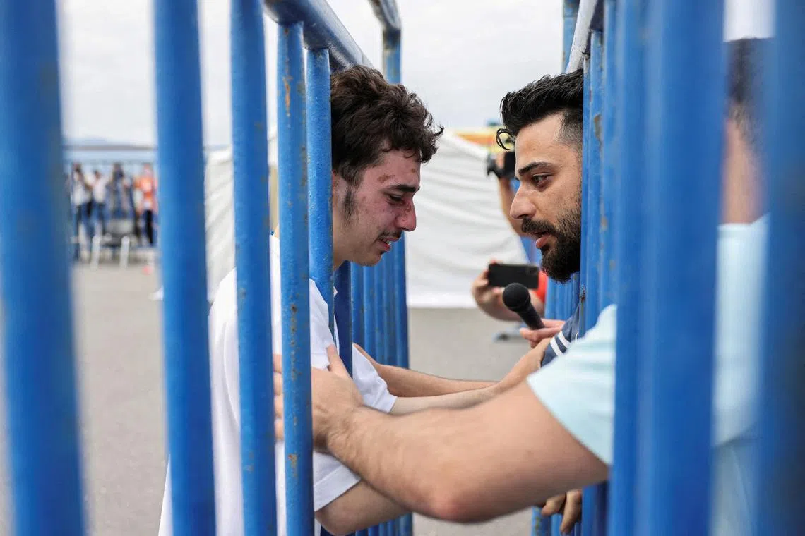 Syrian survivor Mohammad, 18, cries as he reunites with his brother Fadi, at the port of Kalamata, Greece.