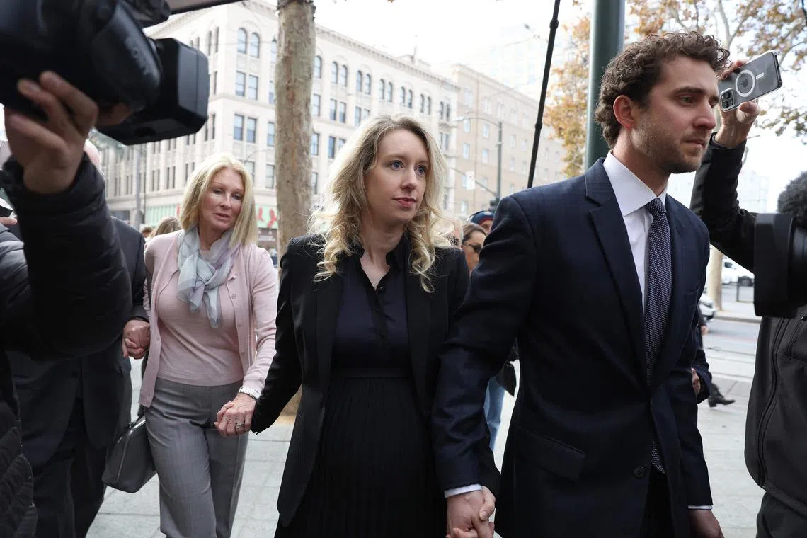 Former Theranos CEO Holmes (centre) arrives at federal court with her partner Billy Evans (right) and mother Noel Holmes in November 2022 in San Jose, California. 
