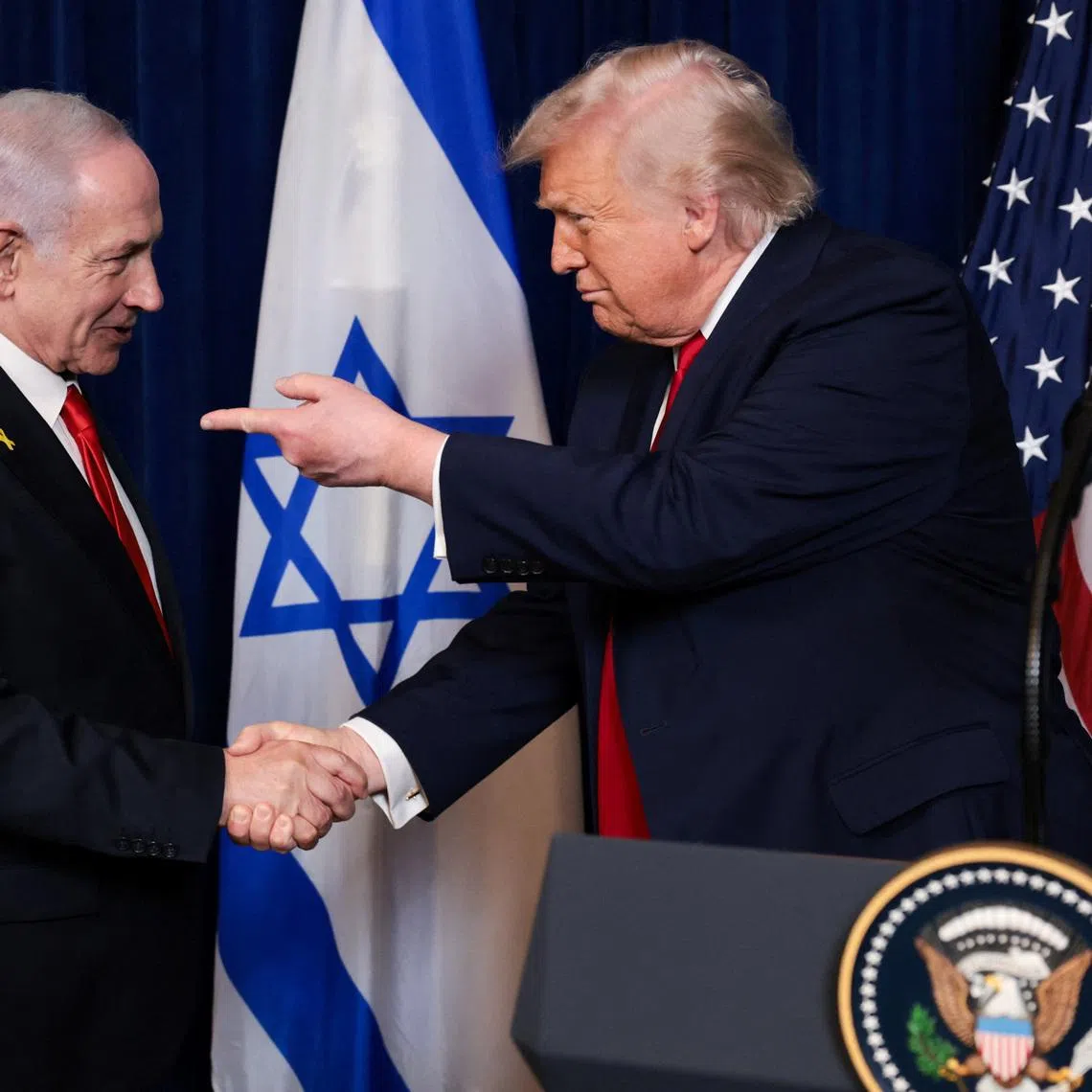 U.S. President Donald Trump points his finger towards Israeli Prime Minister Benjamin Netanyahu as they shake hands during a press conference after meeting at Trump’s Mar-a-Lago club in Palm Beach, Florida, U.S., December 29, 2025. REUTERS/Jonathan Ernst/File Photo
