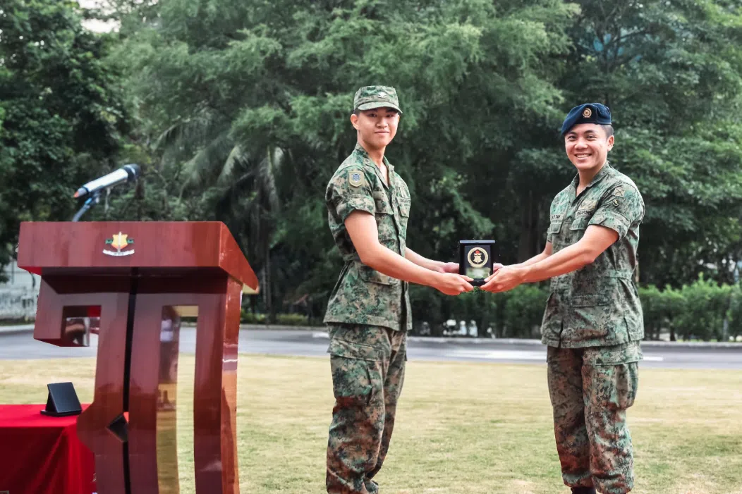 ltc brandon tan (right) presents a plaque to a soldier from 30 singapore combat engineers, singapore army