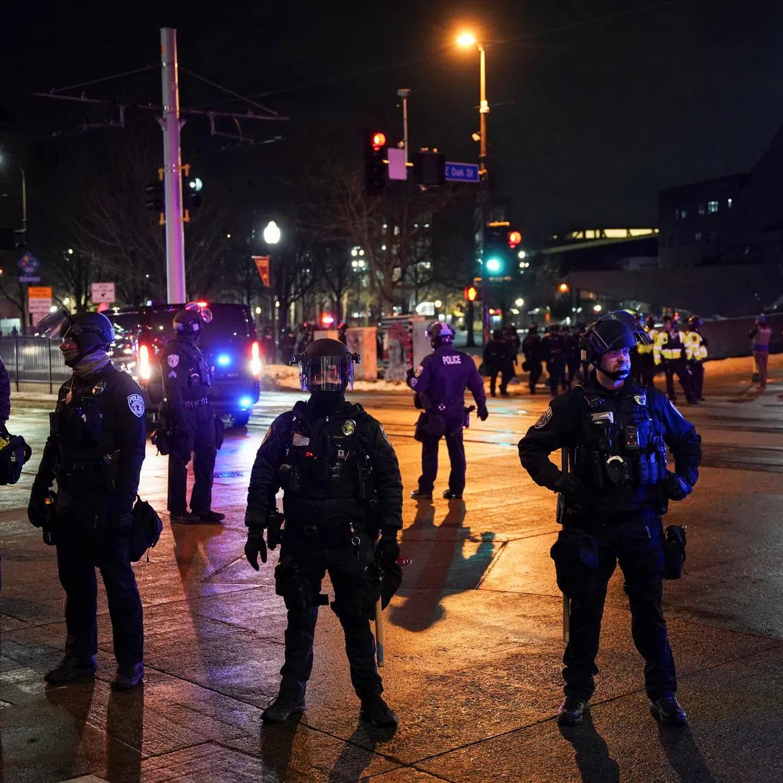 Police officers stand guard as demonstrators gathered outside a hotel amid increased immigration enforcement in Minneapolis, Minnesota on Feb 5.