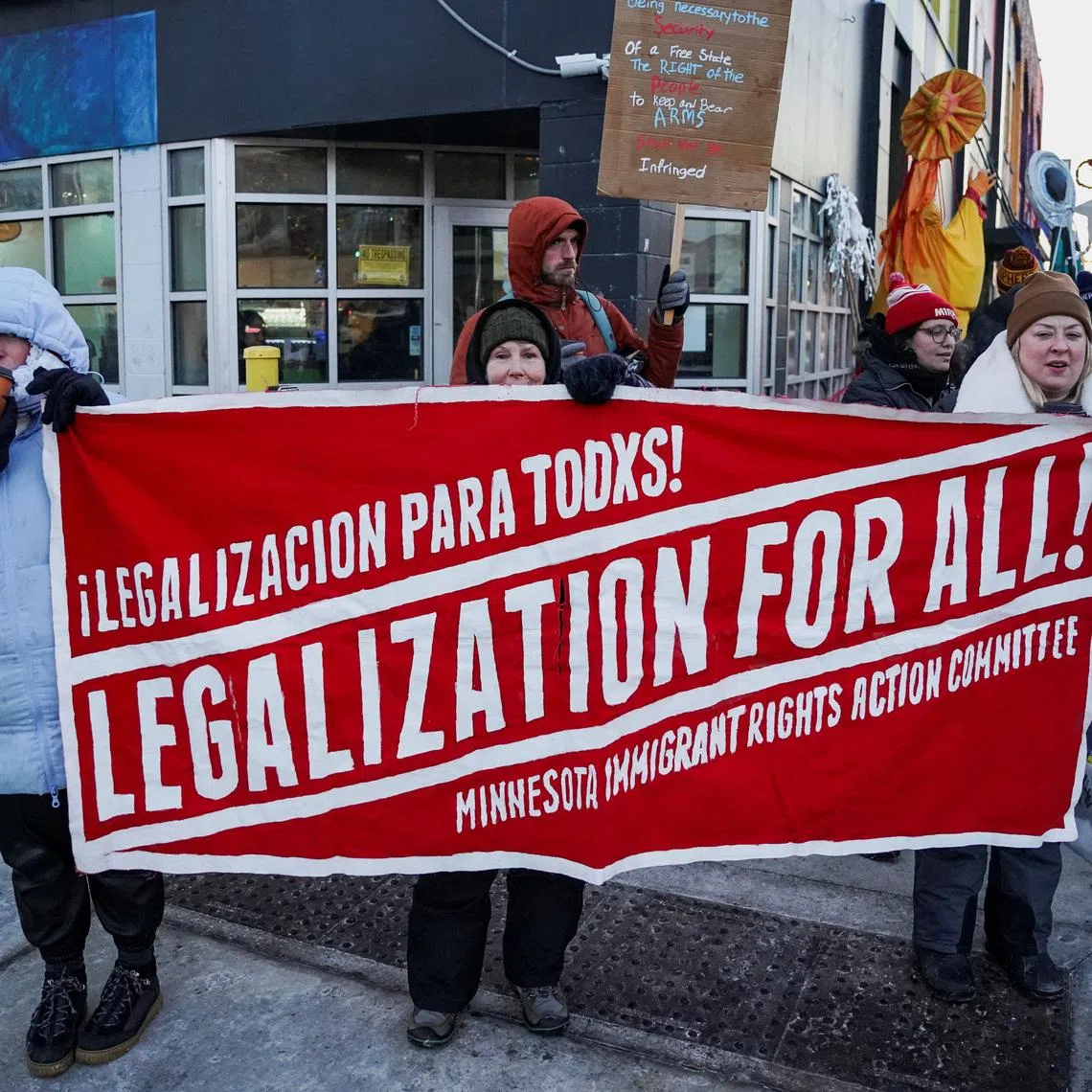 People hold a banner during a demonstration against the presence of federal immigration agents in Minneapolis, Minnesota, U.S., January 28, 2026. REUTERS/Seth Herald