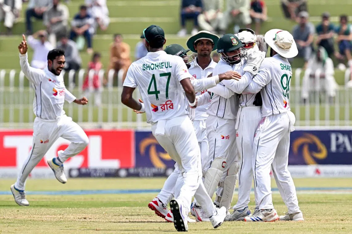 Bangladesh's Mehidy Hasan Miraz (left) celebrates with teammates after taking the wicket of Pakistan's Agha Salman (not pictured) on the fifth and final day of the first Test cricket match in Rawalpindi on Aug 25, 2024.