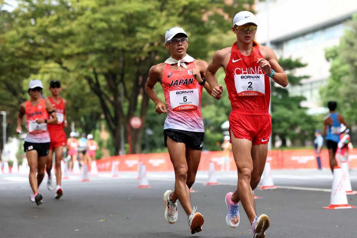 Asian Games - Aichi-Nagoya 2026 - Race Walk - Aichi Prefectural Government Office and Nagoya City Hall Loop Course, Nagoya, Japan - September 23, 2026 Japan's Toshikazu Yamanishi and China's Shengji Shi in action during the men's half marathon race walk REUTERS/Andrew Boyers