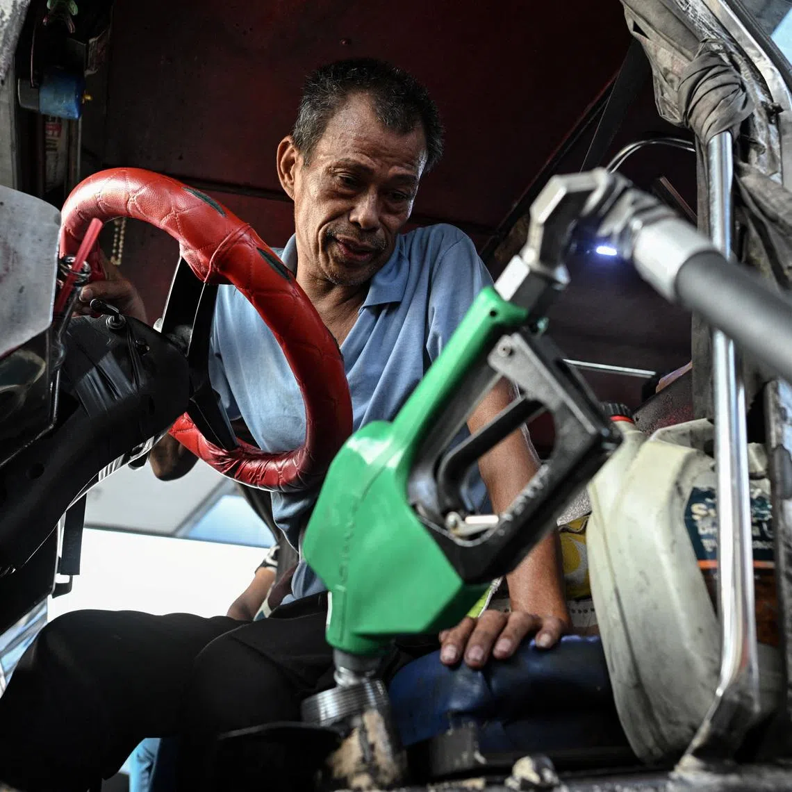 A driver in the Philippines refills his jeep with diesel. The Philippines grappling with shortages caused by the Iran war.