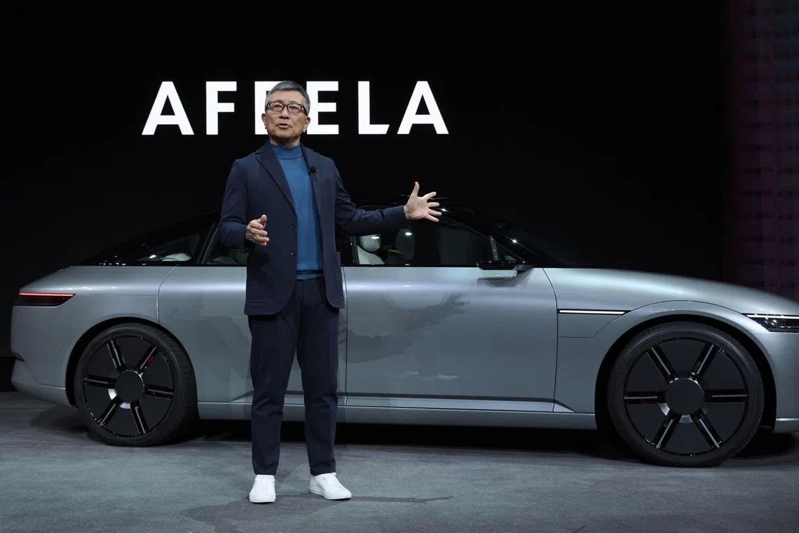 CEO of of Sony Honda Mobility Inc. Yasuhide Mizuno speaks in front of an Afeela prototype at the 2023 Consumer Electronics Show.