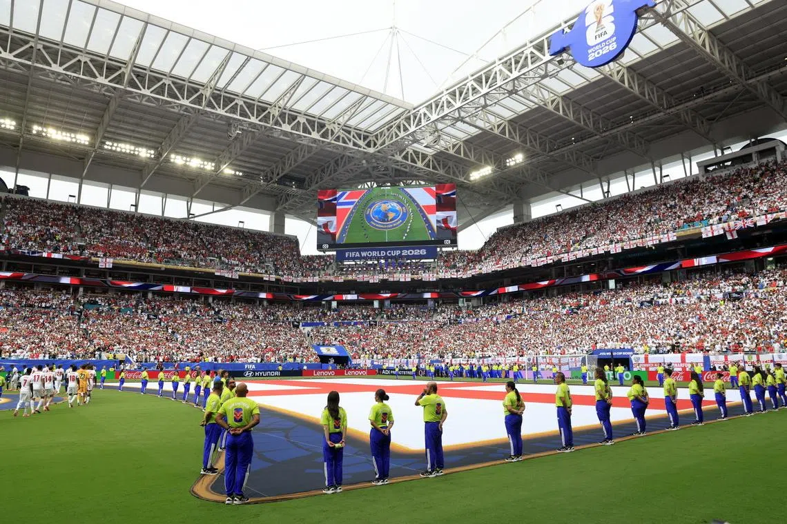 It takes coordination (and many arms) to unfurl a World Cup flag
