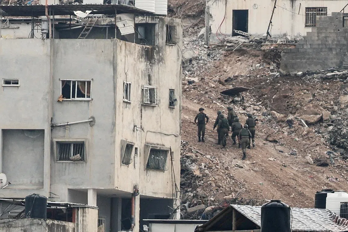 FILE PHOTO: Israeli military members walk during an Israeli army operation in Jenin, in the Israeli-occupied West Bank, February 3, 2025. REUTERS/Raneen Sawafta/File Photo