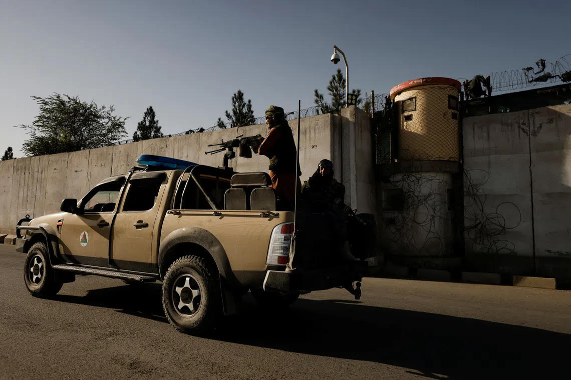 Taliban fighters ride on the back of a pickup truck as they patrol along a road in Kabul, Afghanistan October 23, 2021. REUTERS/Zohra Bensemra