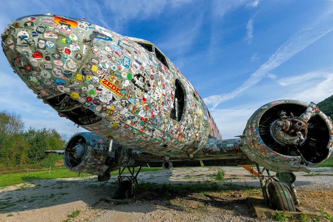 Taken on October 4, 2023 shows Douglas C-47 B Dakota American army airplane covered with stickers at the Zeljava underground army airbase in the heart of the Pljesevica mountain, on Croatia’s border with Bosnia. Designed to withstand a nuclear strike, the Zeljava airbase was constructed in secrecy in the 1960s in what was then Yugoslavia. Authorities in the area have high hopes that with the right marketing, the base could attract  some of the 1.7 million annual tourists that visit the Plitvice Lakes national park just 20 kilometres away. 