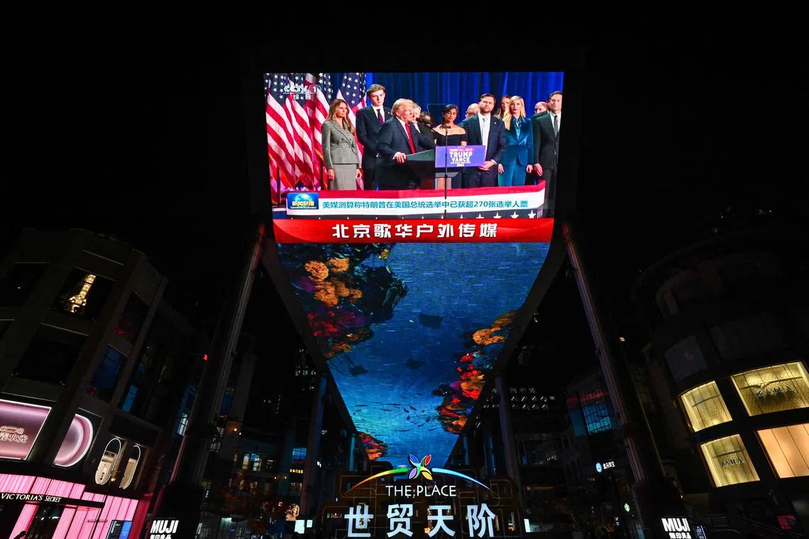 This photo shows a general view of a screen broadcasting news on the US election results outside a mall in Beijing on November 6, 2024. Donald Trump has won the US presidential election, US media announced on November 6, beating Democrat Kamala Harris to complete a stunning political comeback. (Photo by ADEK BERRY / AFP)