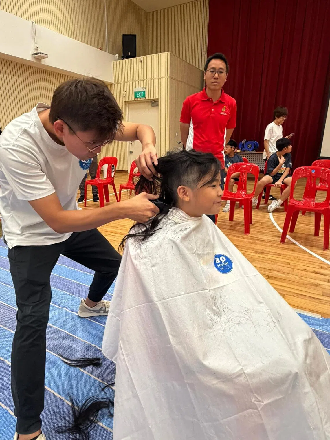 Primary 3 student Joy Ang, 9, shaving her head at Kong Hwa School’s Hair for Hope event on May 22.
