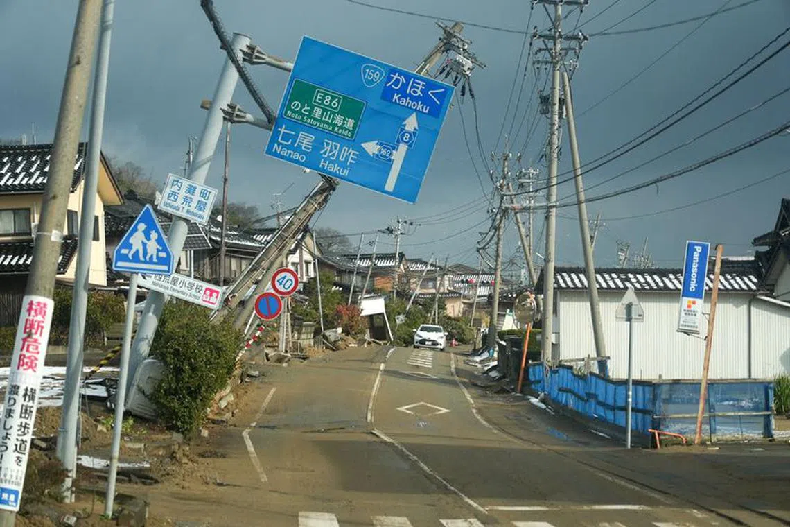 FILE PHOTO: Road signs are tilted over a road damaged by the January 1 earthquake in Nishiaraya, Ishikawa Prefecture, Japan January 8, 2024. REUTERS/Joseph Campbell/File Photo