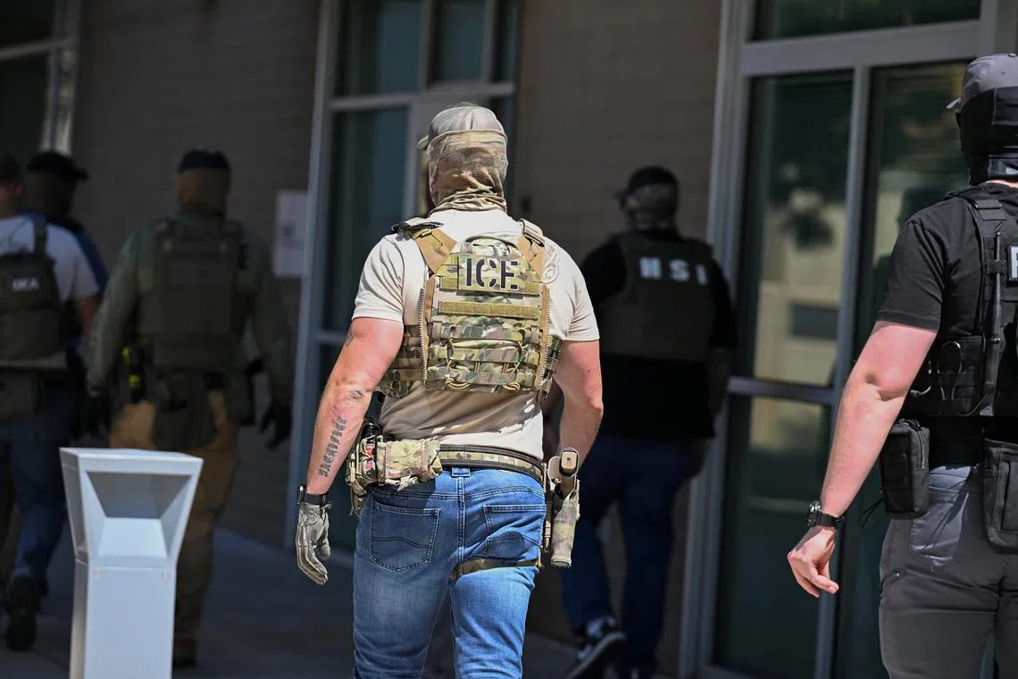 FILE PHOTO: Masked law enforcement officers, including HSI and ICE agents, walk into an immigration court in Phoenix, Arizona, U.S., May 21, 2025.  REUTERS/Caitlin O'Hara/File photo