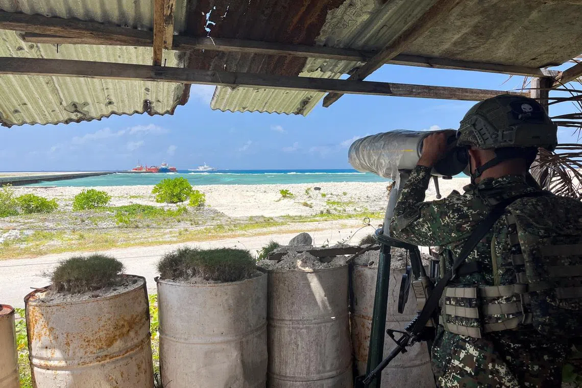 A Philippine soldier peers through an observation telescope from a viewing deck in Philippine-occupied Thitu Island in the disputed South China Sea, February 21, 2026. Picture taken with a mobile phone. REUTERS/Karen Lema