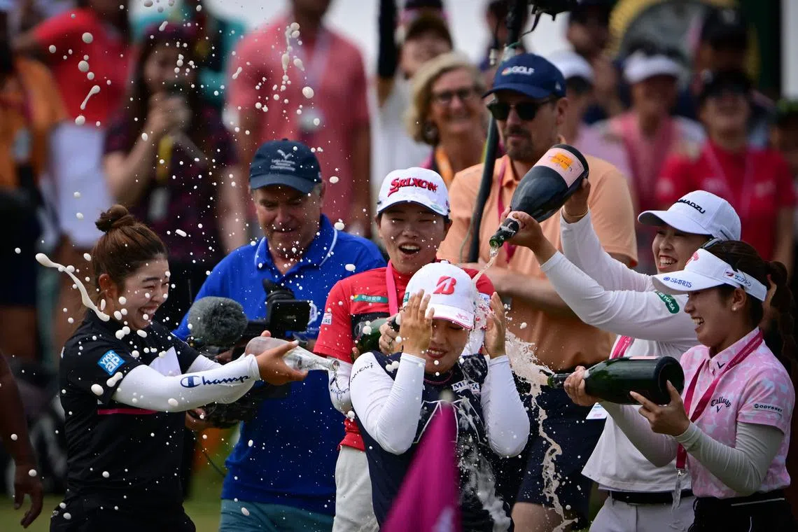 Japan's Ayaka Furue (centre) is showered with champagne as she celebrates after victory following the final round of the Evian Championship on July 14.