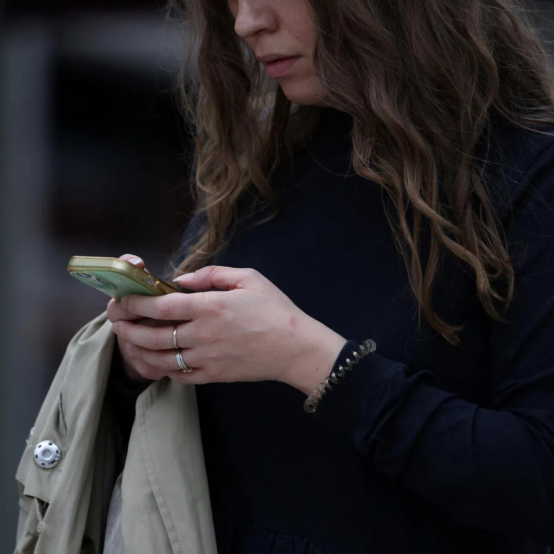 A woman uses a smartphone in London, Britain, October 6, 2024. REUTERS/Hollie Adams