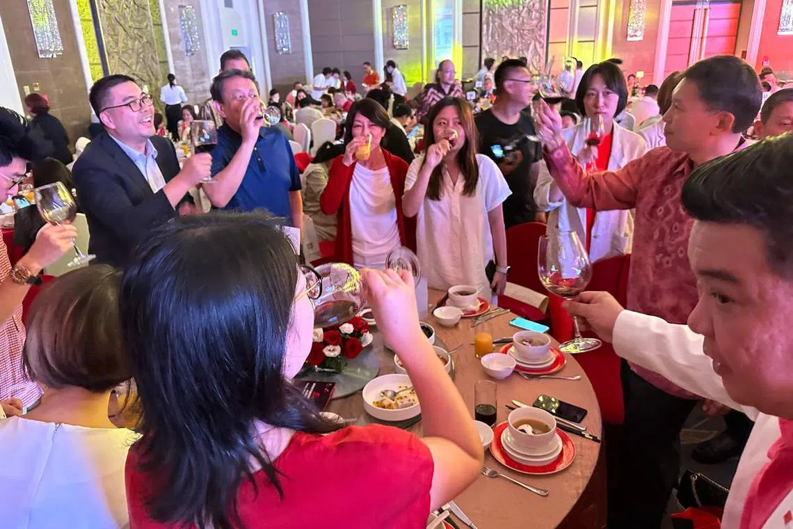 Acting Minister for Transport Chee Hong Tat (right) shares a toast with attendees of a National Day dinner event in Beijing on Saturday (Aug 19). 