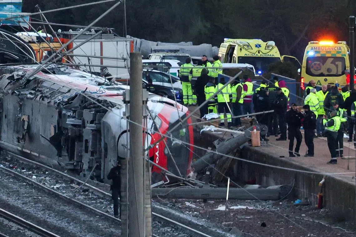 Members of the Spanish Civil Guard, along with other emergency personnel, work next to one of the trains involved in the accident, at the site of a deadly derailment of two high-speed trains near Adamuz, in Cordoba, Spain, January 19, 2026. REUTERS/Susana Vera