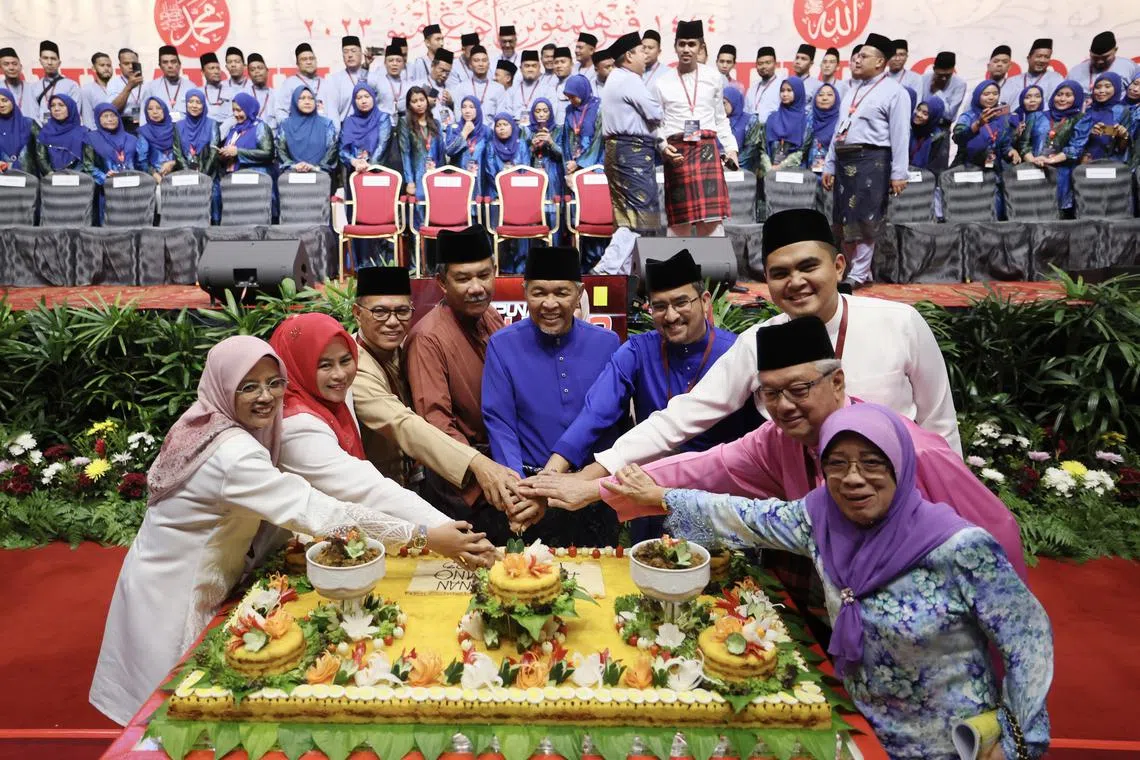 Umno president and Malaysian DPM Zahid Hamidi (centre) leading the cutting of the pulut kuning at the party's annual assembly on June 10.
