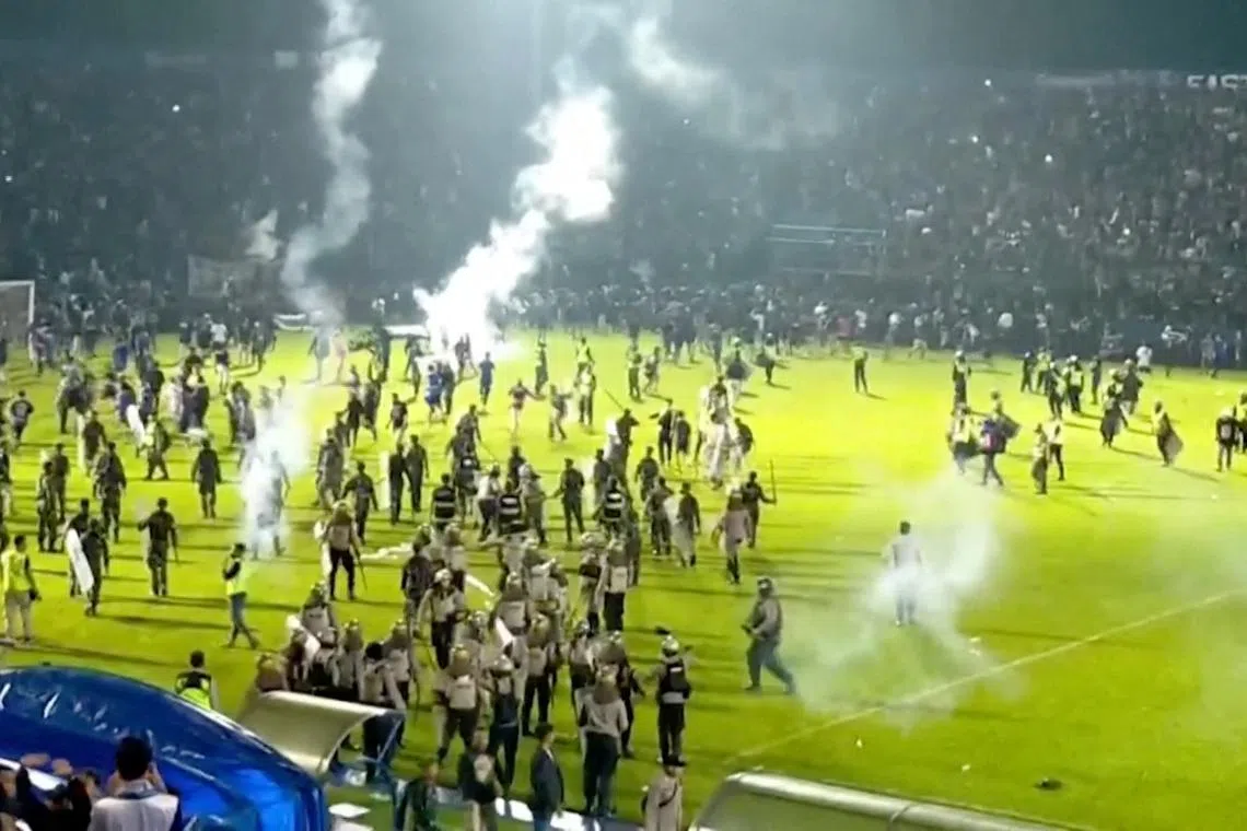 FILE PHOTO: Fans invade the soccer field after a match between Arema FC and Persebaya Surabaya at Kanjuruhan Stadium, Malang, Indonesia Oct 2, 2022 in this screen grab taken from a REUTERS video. REUTERS TV via REUTERS/File Photo