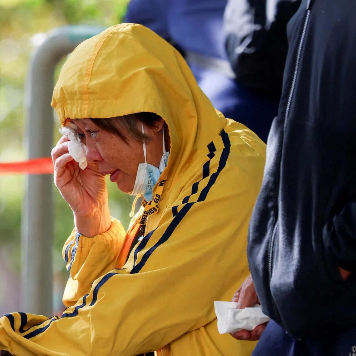 A woman cries outside a community hall, as firefighters search for survivors of a fire that gutted the Wang Fuk Court housing complex.

