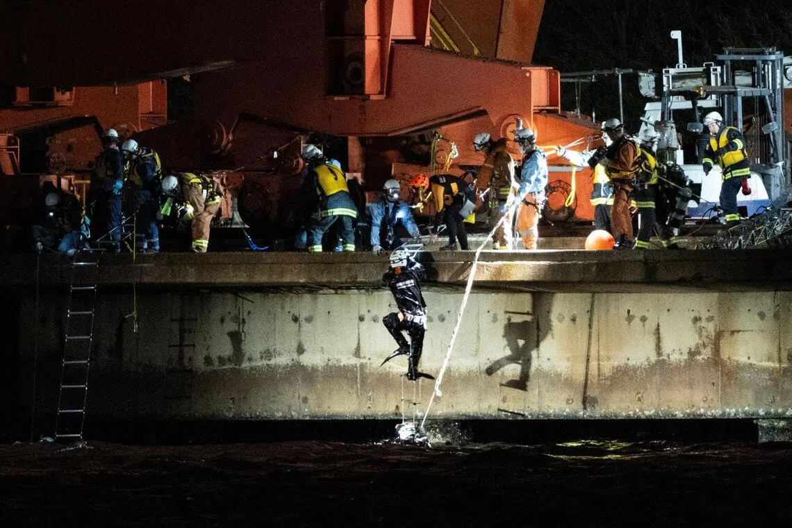 Emergency swimmers climb out of the water at the JFE Steel East Japan Works Keihin District construction site in Kawasaki, Kanagawa prefecture, on April 7.
