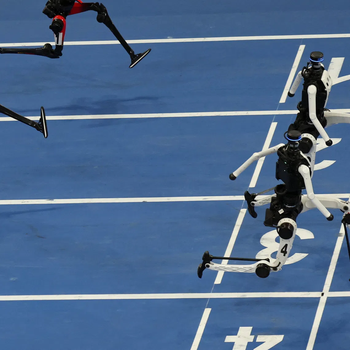 Tiangong Ultra humanoid robots cross the finish line before Honor's Lightning humanoid robots in the 100m large-size group final race, during the second World Humanoid Robot Games at the National Speed Skating Oval in Beijing, China August 26, 2026. REUTERS/Florence Lo