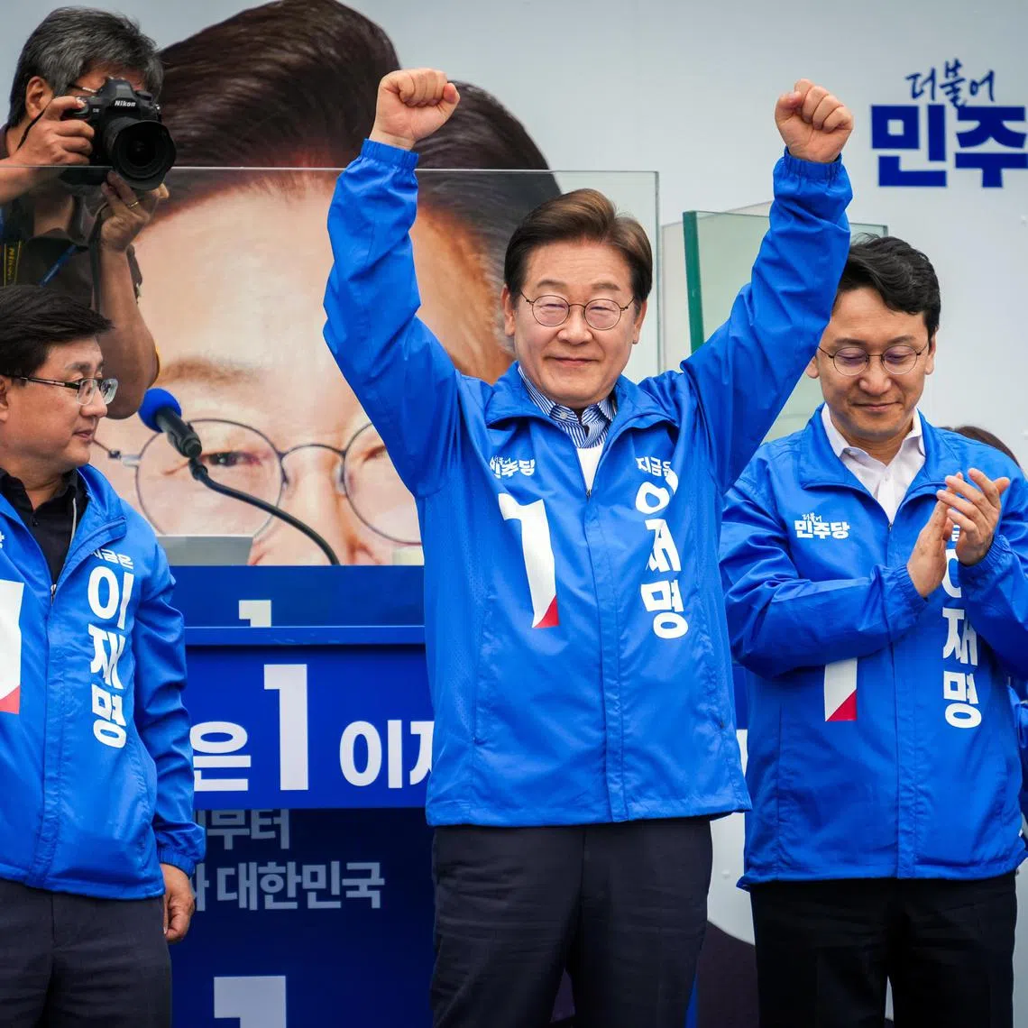 Lee Jae-myung, the Democratic Party candidate for president, raises his arms as he is appluaded at a campaign rally in Seoul on Monday, June 2, 2025. Lee, who is leading in polls, has said he would use his power to bring the country together and revive the economy.  (Jun Michael Park/The New York Times)