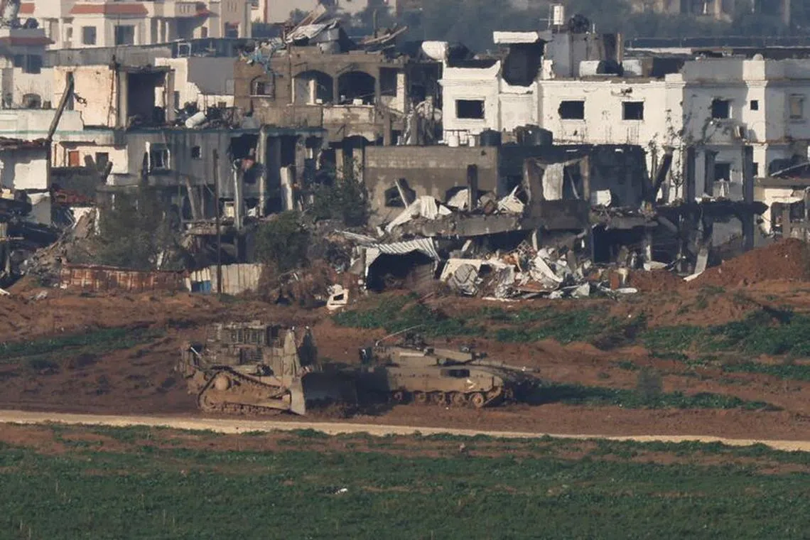 Israeli military vehicles manoeuvre in Gaza, amid the ongoing conflict between Israel and the Palestinian Islamist group Hamas, as seen from Israel, January 12, 2024. REUTERS/Tyrone Siu