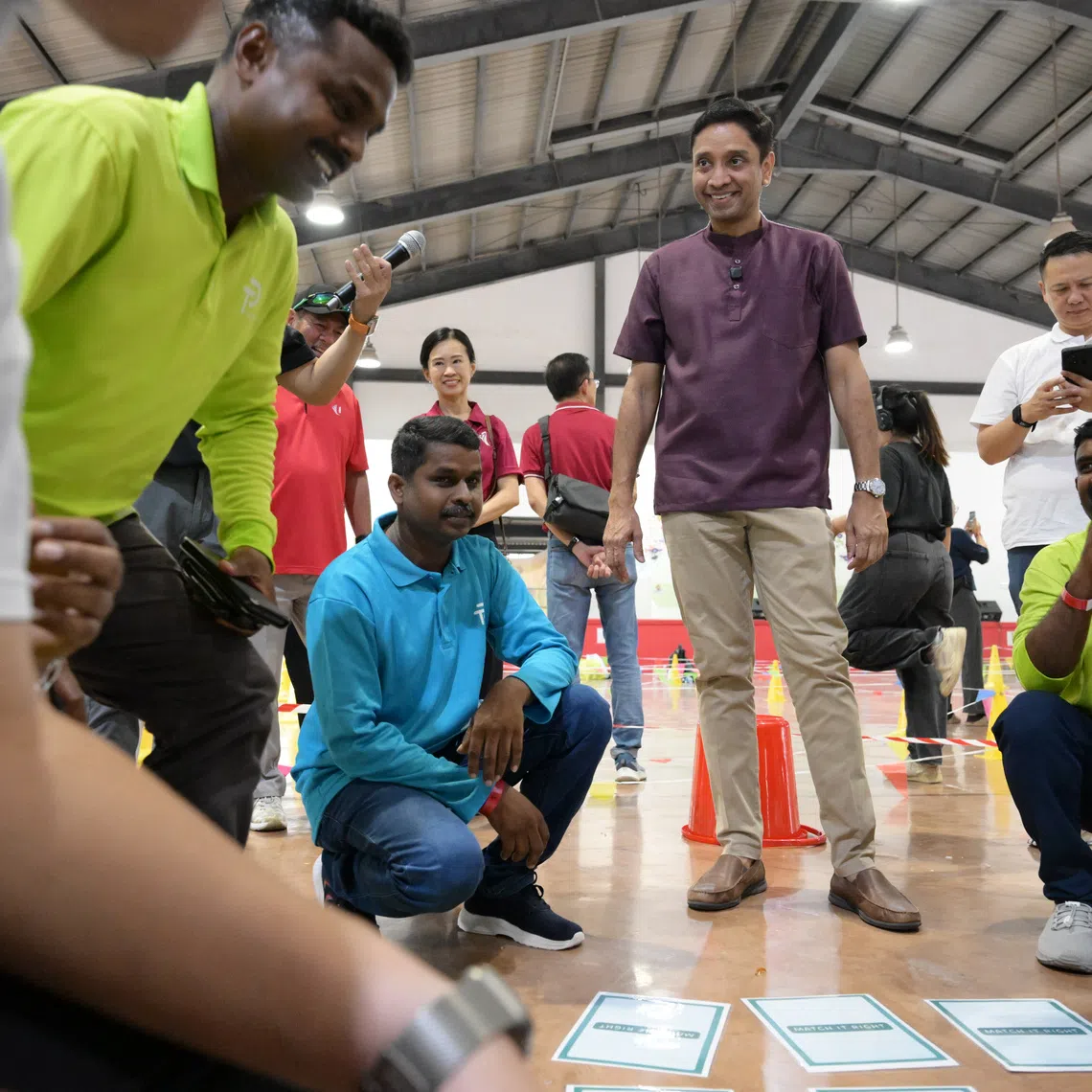 Minister of State for Manpower Dinesh Vasu Dash (in purple) engaging in a game with migrant workers at Terusan Recreation Centre on Oct 5.