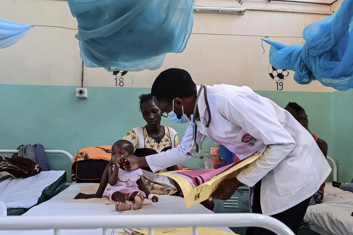 A medic checks on a toddler admitted at a paedeatric stabilisation ward at the Lodwar County Refferal Hospital on September 26, 2022 where a worsening drought due to continued failed rainy seasons has seen scores of local residents suffer malnutrition in Turkana county. - The United Nations warned that countries in the horn of Africa more Somalia and similarly Kenya's arid nothern reaches are on the brink of famine for the second time in just over a decade. (Photo by Tony KARUMBA / AFP)