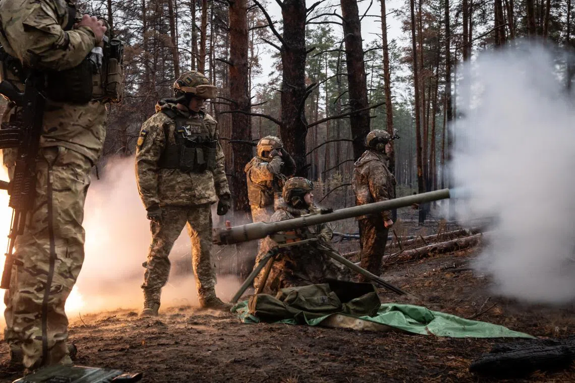 Ukrainian soldiers fire a grenade launcher towards Russian forces, near the Kreminna front line, in the Donetsk region of Ukraine.