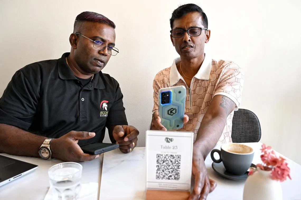 Mr Annadurai Periyasamy (right) said he was grateful to learn how to use a smartphone again after his release, from facilitators such as Mr Murugason Mutthiah in Project ReConnect.